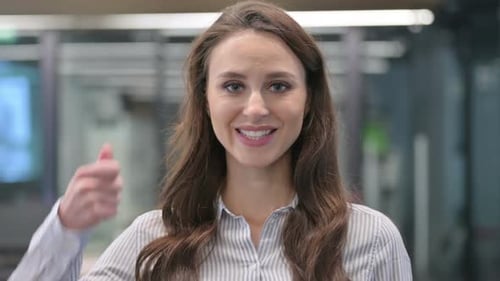 Young Adult Woman Giving a Thumbs Up in Office
