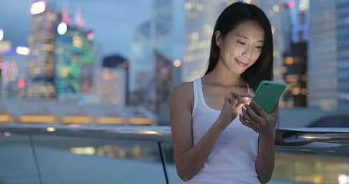 Woman using mobile phone at night
