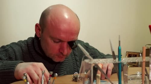 Focused Man Repairing Watch with Magnifying Glass