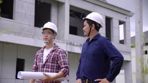 construction engineers and owner discussing together with the blueprint and drawing