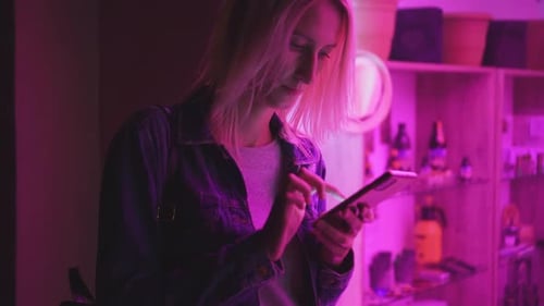 Woman Using Smartphone with Neon Lighting