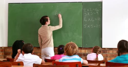 Pretty Teacher Teaching Math to her Class and Smiling at Camera