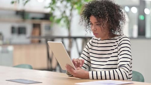 Young African Woman Using Tablet in Office
