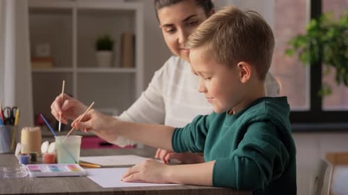Cheerful Woman and Boy Painting Together Indoors