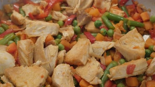 Tasty lunch in frying pan close-up 4K 2160p 30fps UltraHD video - Mix of vegetables with poultry me