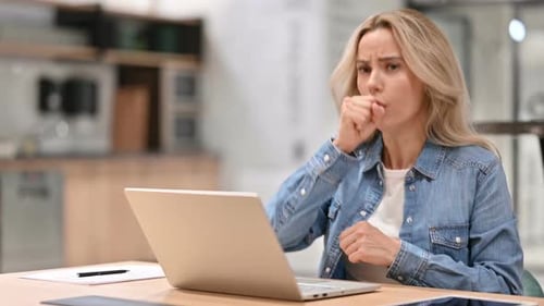 Woman Coughing While Using Laptop at Work