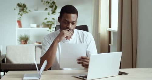 Young Adult Working at Desk with Laptop