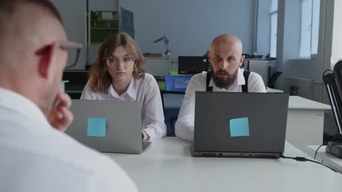 Des collègues discutent du travail en ligne au bureau