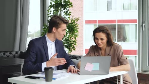 4K Young casual business group in a meeting in creative office with woman working on computer