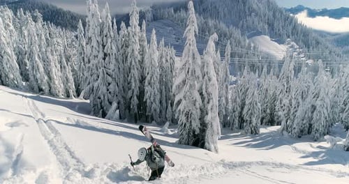 Male Skier Hiking Trail In Mountainous Snow Covered Backcountry - Aerial Drone View
