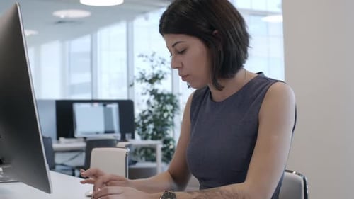 Young Female Clerk Typing on Computer