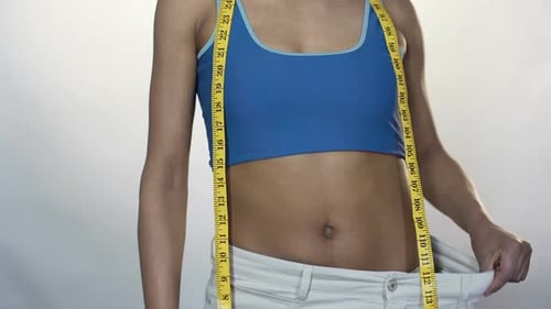 Woman Showing Weight Loss with Pants and Tape