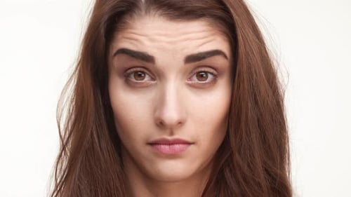 Close Up Footage of Skeptical Beautiful Caucasian Female Standing on White Background Looking