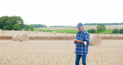 Farmer Using Digital Tablet While Examining Field