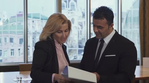 Business Professionals Review Documents in Modern Office