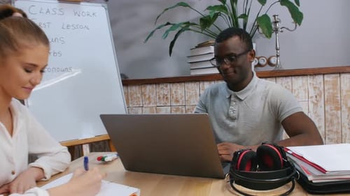 Two Young Adults Studying at Desk