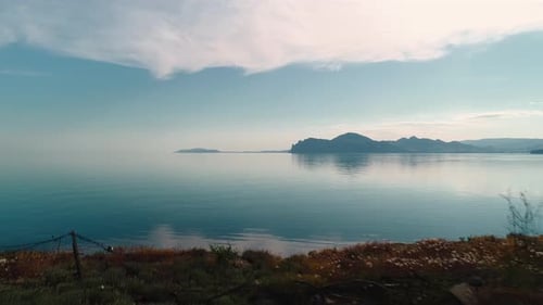 Mountain coast on horizon near mirror water