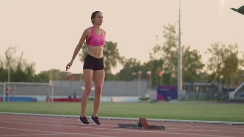 Woman Athlete Preparing to Run at Outdoor Track