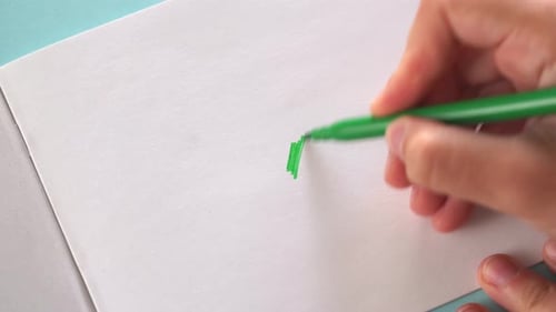 Drawing a Green Scribble on White Paper