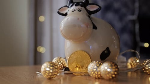 Cow Figurine with Gold Bitcoin on Wood Surface
