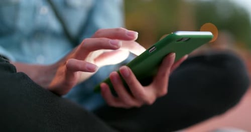 Frau benutzt Smartphone im Freien