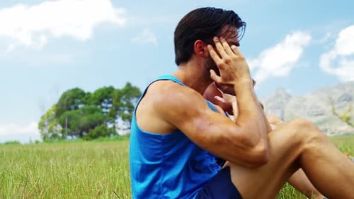 Young Adults Doing Crunches Exercise in Field