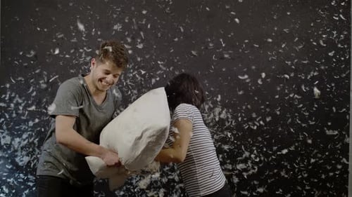 Feliz pareja teniendo una pelea de almohadas, Ultra Cámara lenta