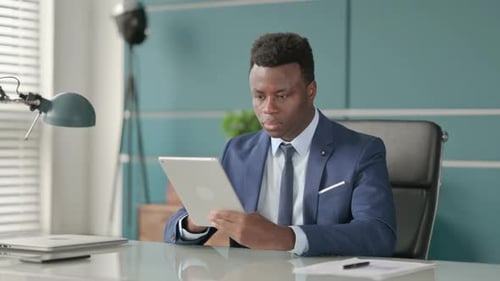 African Businessman Using Tablet While Sitting in Office
