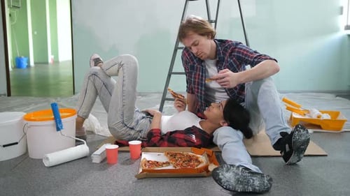 Young Couple Eating Pizza During Home Improvement Break