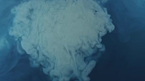 Abstract White Ink Swirling in Blue Liquid