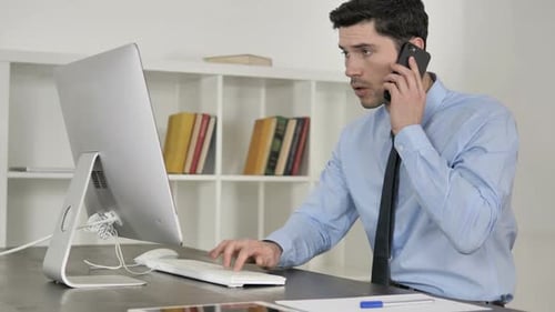 Geschäftsmann telefoniert und benutzt Computer