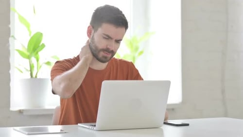 Man Working at Computer Experiences Neck Pain