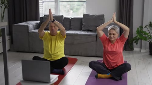 Mature Couple Doing Yoga Together at Home