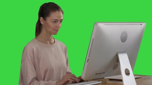 Woman Freelancer Is Working on a New Project on Computer on a Green Screen, Chroma Key
