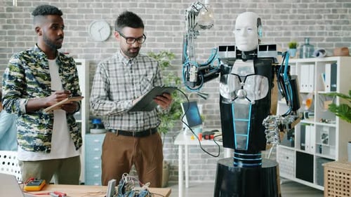 Engineers Testing Robot in Office Working with Tablet Discussing Ai Smiling