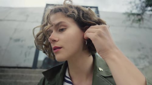Young Adult Putting in Wireless Earbud