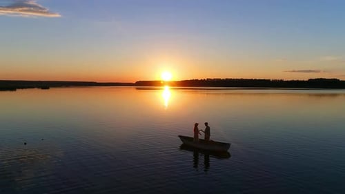 Love Story in the Boat, Sunset on a Lake or River - Drone Footage