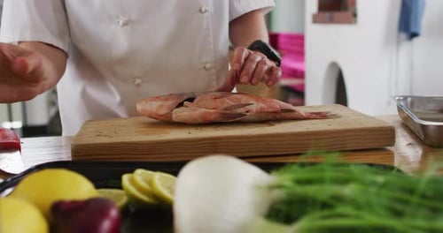 Chef Preparing Fish in Bright Kitchen