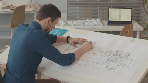 Architect Drawing Blueprint in Office Environment