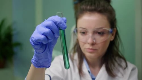 Young Woman Scientist Examining Test Tube Liquid