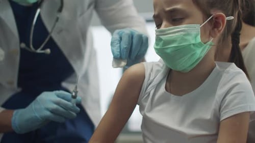 Child Receiving Vaccine Injection From Medical Professional