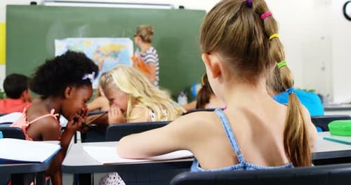 Schoolgirl doing homework in classroom