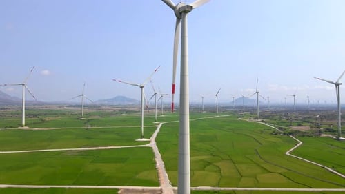 Wind Turbines Spinning in a Vast Green Field