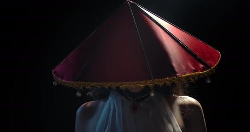 Woman in Decorative Hat on Black Background