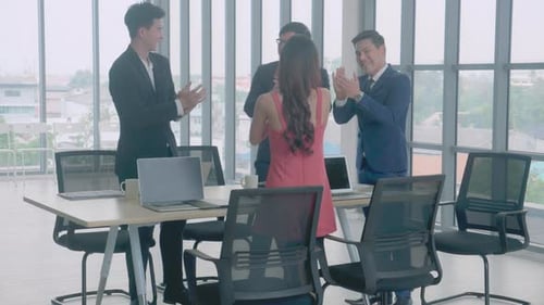 Colleagues Applauding a Co-worker in Bright Office