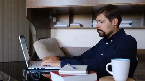 Young Adult Man Working on Laptop at Home