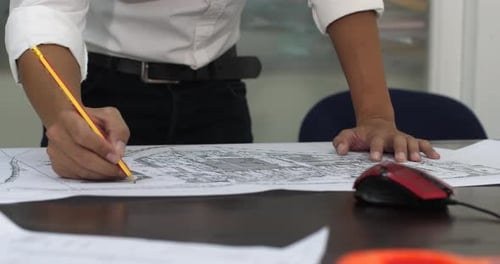 Architects Working With Blueprints In The Office