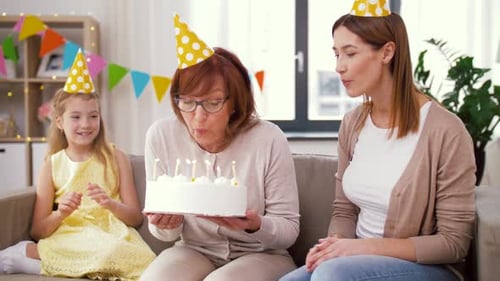 Family Celebrating Birthday and Blowing Out Candles