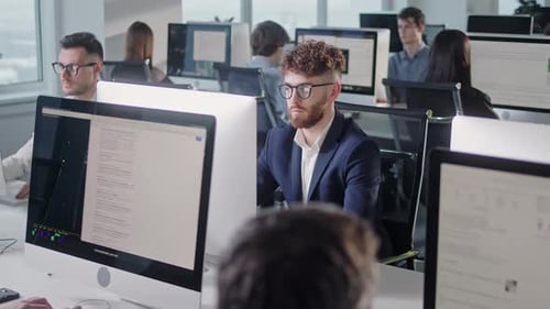 Espace ouvert de bureaux d'entreprise moderne avec un personnel multiculturel occupé, un groupe d'employés utilisant des ordinateurs PC