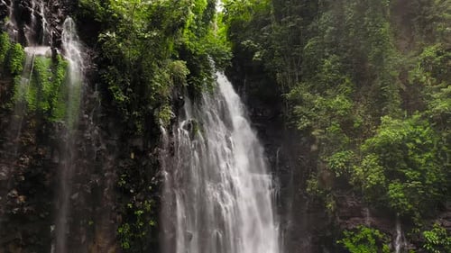 Tropical Waterfall Flowing Through Lush Green Nature